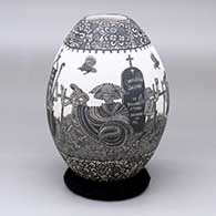 A black-on-white jar decorated with a band of Day of the Dead at the cemetery imagery between two bands of geometric design
 by Hector Javier Martinez of Mata Ortiz and Casas Grandes