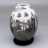 A black-on-white vase decorated with a sgraffito Day of the Dead at the Cemetery design
 by Hector Javier Martinez of Mata Ortiz and Casas Grandes