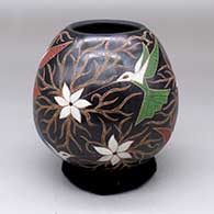 A polychrome jar decorated with a sgraffito-and-painted hummingbird, flower and vine design
 by Elicena Cota of Mata Ortiz and Casas Grandes