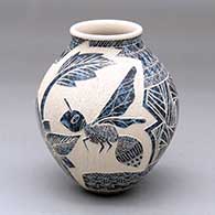 A blue-on-white jar decorated with a lightly-carved-and-sgraffito wasp, flower, leaf and geometric design
 by Hector Quintana of Mata Ortiz and Casas Grandes