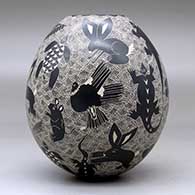 A black-on-white jar decorated with a sgraffito animal, bird, turtle, insect and geometric design, click or tap to see a larger version
