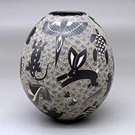A black-on-white jar decorated with a sgraffito animal, bird, turtle, insect and geometric design
 by Alex Ortega of Mata Ortiz and Casas Grandes
