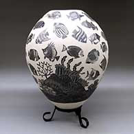 A black-on-white jar decorated with a lightly-carved and sgraffito tropical fish and coral reef design, click or tap to see a larger version