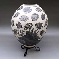 A black-on-white jar decorated with a lightly-carved and sgraffito tropical fish and coral reef design
 by Adrian Corona of Mata Ortiz and Casas Grandes