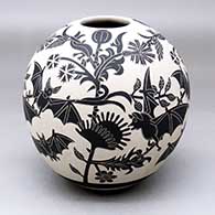 A black-on-white jar decorated with a lightly-carved and sgraffito flying bats, flowers and milk thistle design
 by Adrian Corona of Mata Ortiz and Casas Grandes