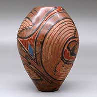 A polychrome mixed clay jar decorated with a carved and painted geometric design, click or tap to see a larger version