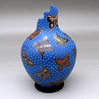 A polychrome jar with a step-cut rim and decorated with a sgraffito-and-painted butterfly and geometric mesh design
 by Elicena Cota of Mata Ortiz and Casas Grandes