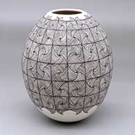 A black-on-beige jar decorated with a mesh geometric design
 by Aide Gonzales of Mata Ortiz and Casas Grandes