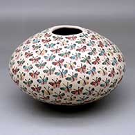 A polychrome seed pot decorated with a sgraffito and painted butterfly design
 by Celia Lopez of Mata Ortiz and Casas Grandes