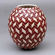 A red-on-white jar decorated with a sgraffito 3D geometric design
 by Leonel Lopez Jr of Mata Ortiz and Casas Grandes