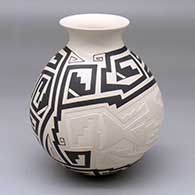 A black-on-beige jar with a recurved rim and decorated with a lightly-carved, sgraffito and painted two-panel fish and geometric design
 by Claudia Ledezma of Mata Ortiz and Casas Grandes