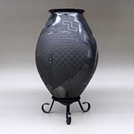 A matte and polished black jar with a flared rim and decorated with a sgraffito and painted two-panel serpent and geometric design, click or tap to see a larger version