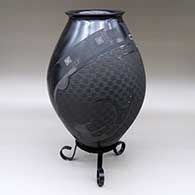 A matte and polished black jar with a flared rim and decorated with a sgraffito and painted two-panel serpent and geometric design
 by Roberto Almeraz of Mata Ortiz and Casas Grandes