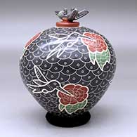 A polychrome jar decorated with a lightly carved, sgraffito and painted hummingbird, flower and geometric design, with a matching hummingbird lid, click or tap to see a larger version