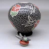 A polychrome jar decorated with a lightly carved, sgraffito and painted hummingbird, flower and geometric design, with a matching hummingbird lid, click or tap to see a larger version