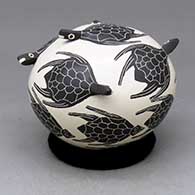 Click for a larger view A black on beige seed pot decorated with turtle head appliques and bands of swimming turtles
by Efren Ledezma of Mata Ortiz and Casas Grandes