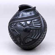 A black jar with an organic opening and decorated with a carved and sgraffito two-panel serpent, hummingbird and geometric design
 by Martin Olivas of Mata Ortiz and Casas Grandes