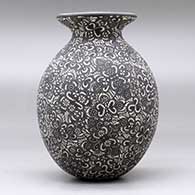 A black on white jar with a flared rim and decorated with a sgraffito geometric design, click or tap to see a larger version