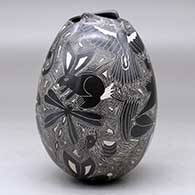 A black on white jar with a geometric cut opening and decorated with a sgraffito wildlife and geometric design, click or tap to see a larger version