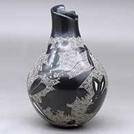 A black on white jar with a geometric cut opening on a short neck and decorated with a sgraffito wildlife and geometric design, click or tap to see a larger version