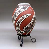 A polychrome jar lightly carved and painted with a three-panel serpent, sickle and geometric design, click or tap to see a larger version