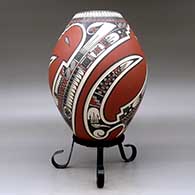 A polychrome jar lightly carved and painted with a three-panel serpent, sickle and geometric design, click or tap to see a larger version