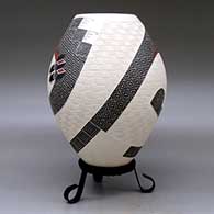 A polychrome jar decorated with a two-panel carved, sgraffito and painted stylized serpent, checkerboard and geometric design, click or tap to see a larger version