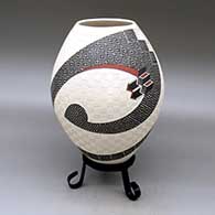 A polychrome jar decorated with a two-panel carved, sgraffito and painted stylized serpent, checkerboard and geometric design
 by Roberto Olivas of Mata Ortiz and Casas Grandes