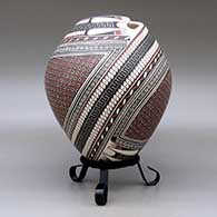 A polychrome jar with a geometric cut opening and decorated with a two-panel tiny square and geometric design, click or tap to see a larger version
