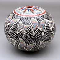 A polychrome seed pot decorated with a sgraffito and painted butterfly, medallion and geometric design
 by Oscar Ramirez of Mata Ortiz and Casas Grandes