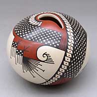 A polychrome seed pot with a geometric cut opening and decorated with a stylized serpent, bird element and geometric design
 by Vidal Corona of Mata Ortiz and Casas Grandes