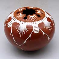 Click for a larger view A white on red jar decorated with a five-panel geometric design matching a five-directional geometric cut opening in the top
by Avelina Corona of Mata Ortiz and Casas Grandes