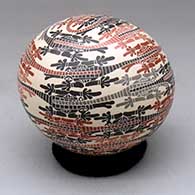 A polychrome seed pot decorated with a sgraffito and painted crocodile and geometric design
 by Efren Ledezma of Mata Ortiz and Casas Grandes