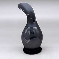 A black on black flower-like jar with a kiva step cut neck and decorated with a painted geometric and sgraffito design
 by Susy Martinez of Mata Ortiz and Casas Grandes