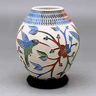 A polychrome jar decorated with a three-panel hummingbird, branch, leaf, flower and geometric design
 by Lupita Quezada of Mata Ortiz and Casas Grandes