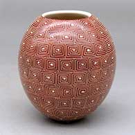 A red on white jar decorated with a sgraffito square-spiral geometric design
 by Leonel Lopez Jr of Mata Ortiz and Casas Grandes