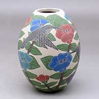 A polychrome jar decorated with a sgraffito and painted bird, butterfly, flower, branch and leaf design
 by Karla Flores of Mata Ortiz and Casas Grandes