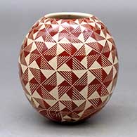 A red on white jar decorated with a sgraffito geometric design from top to bottom
 by Leonel Lopez Jr of Mata Ortiz and Casas Grandes