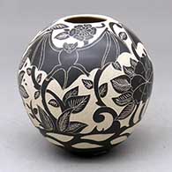 A small black on white jar decorated with a bat and nature design
 by Diana Loya of Mata Ortiz and Casas Grandes