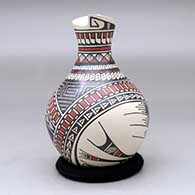 A polychrome vase with a geometric cit rim and decorated with a stylized serpent and geometric design
 by Mirna Hernandez of Mata Ortiz and Casas Grandes