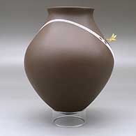 A white on brown jar with a recurved neck and decorated with a geometric design with a hummingbird hovering above the shoulder, click or tap to see a larger version