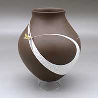 A white on brown jar with a recurved neck and decorated with a geometric design with a hummingbird hovering above the shoulder
 by Diego Valles of Mata Ortiz and Casas Grandes