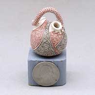 A miniature double spout canteen with a snake for a handle and decorated with a fineline and geometric design
 by Carla Martinez of Mata Ortiz and Casas Grandes