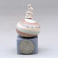 A lidded miniature polychrome jar decorated with a serpent, fineline and geometric design, click or tap to see a larger version