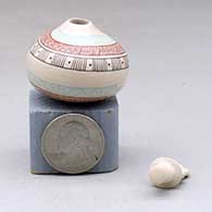 A lidded miniature polychrome jar decorated with a serpent, fineline and geometric design, click or tap to see a larger version