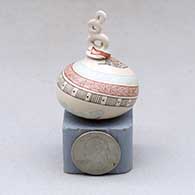 A lidded miniature polychrome jar decorated with a serpent, fineline and geometric design
 by Carla Martinez of Mata Ortiz and Casas Grandes