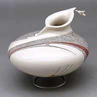 A polychrome sculptural jar decorated with a fineline and geometric design and a hummingbird hovering near the rim
 by Carla Martinez of Mata Ortiz and Casas Grandes