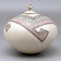 A polychrome jar decorated with a fineline and geometric design and a seated matachine on the lid, click or tap to see a larger version