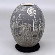 A black on white jar decorated with a sgraffito Night of the Dead at the cemetery design
 by Hector Javier Martinez of Mata Ortiz and Casas Grandes