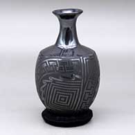 A black on glossy black vase with a flared neck and decorated with a three panel tiny square and geometric design around the body
 by Eligio Ortiz of Mata Ortiz and Casas Grandes